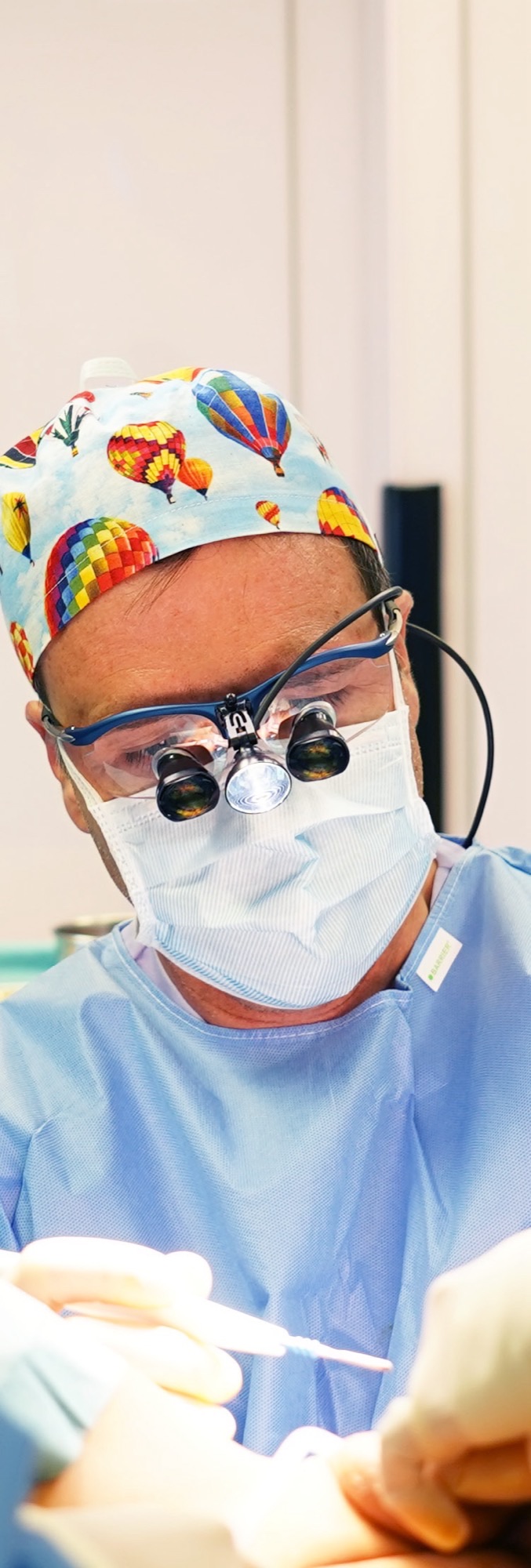 El Dr. Iván Mañero operando con lupas en un quirófano de IM Clinic